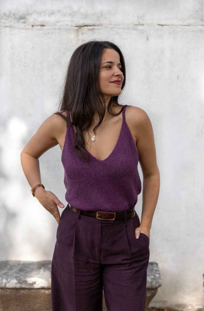 Vânia Ribeiro de top roxo, com a mão na cintura